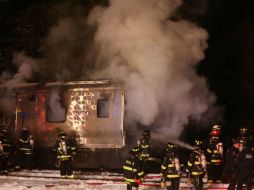 Los bomberos trabajan por apagar el fuego provocado por la colisión. AP / F. Becerra Jr.