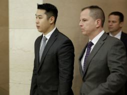 Espectadores de la audiencia, y familiares del difunto Gurley, insultan al policía al salir del tribunal. AP / S. Wenig