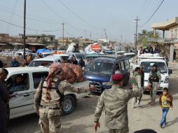 Militares iraquíes ayudan a los ciudadanos a regresar a la aldea de Al-Mansuriya tras los ataques yihadistas. AFP / Y. Al-Bayati