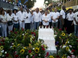 El presidente Michel Martelly (c) se sumó a centenares de personas en una caminata solemne por los fallecidos. AFP / H. Retamal