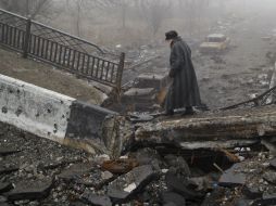 Una mujer cruza un puente destruido cerca del aeropuerto de Donetsk. AP / V. Ghirda