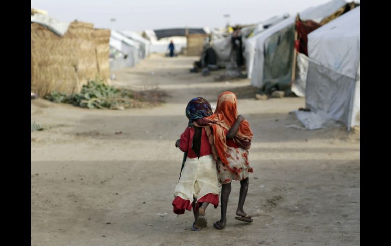 Ami y Ashbu, de tres años, caminan en el campamento de refugiados Zafaye, en N'djamena (Chad), donde viven con cinco mil refugiados. AP / J. Delay