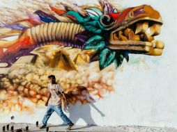 En la imagen se ve a un artista pintando un graffiti del Quetzalcóatl. ESPECIAL / www.worldphoto.org