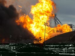 Enormes llamas y nubaredas negras se alzaban contra el cielo azul desde un depósito de tanques de combustible. EFE / S. Moreira
