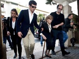 Maria Isabel Brandao (c), viuda del cineasta Manoel de Oliveira, junto a su nieto, Jorge Trepa (i), llegan para el funeral. EFE / R. Castelo