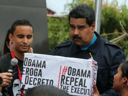 El presidente venezolano sostiene una caja que dice 'Obama deroga el decreto ya', en alusión a que Venezuela representa una amenaza. AP / R. Espinosa