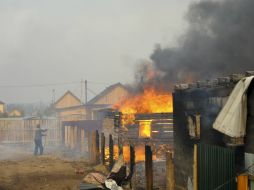 Un hombre intenta salvar su casa del incendio, provocado por quema irresponsable de pastizales y los fuertes vientos de la región. AP / E. Yepanchintsev
