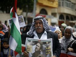 Un hombre palestino sostienen la fotografía de un prisionero en Israel durante la protesta del Día del Prisionero. AFP / M. Abed
