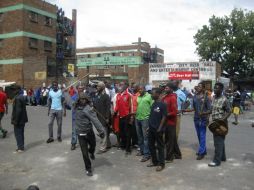 Jóvenes zúlus amenazan con palos y escudos tradicionales con atacar a los inmigrantes de Nigeria que viven en el barrio de Jeppestown. EFE / M. Gascón