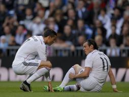 Gareth Bale señala a Cristiano Ronaldo el lugar en su pierna donde siente el dolor por la lesión. AP / A. Kudacki