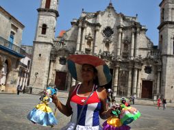 Fe. Una vendedora ofrece su mercancía en la Plaza de la Catedral de La Habana. EFE /