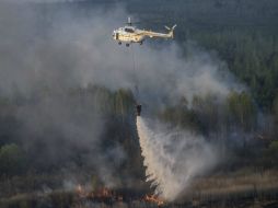 Un helicóptero ucraniano Mi-8 riega con agua un incendio forestal en la zona de exclusión de Chernobil. EFE / A. Kravchenko