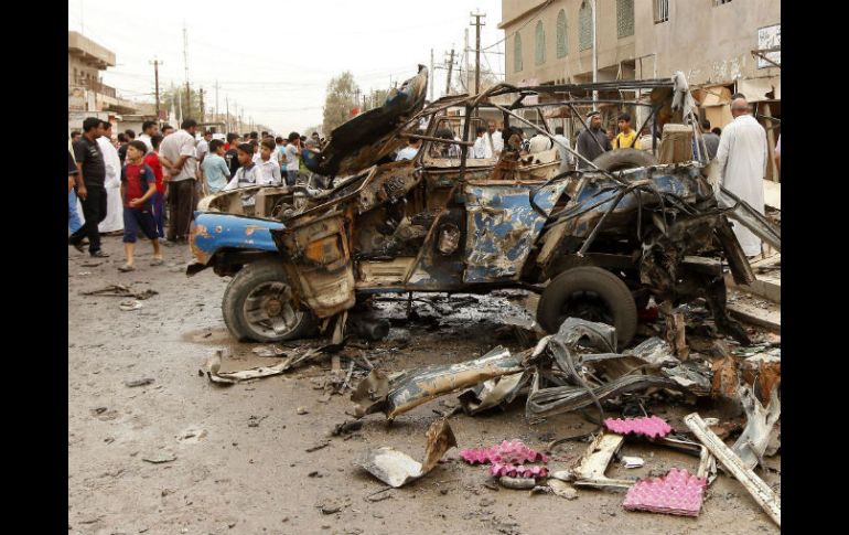 Personas se quedan mirando el vehículo destruido por una bomba del Estado Islámico. EFE / ARCHIVO