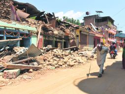 Ruinas. Pobladores recorren una calle devastada por el fenómeno del 25 de abril. AFP /