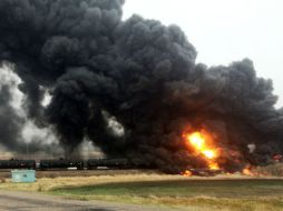 Una gran columna de humo negro se alza sobre el lugar del descarrilamiento. AP / C. Bemson