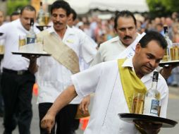 Los competidores debían caminar lo más rápidamente posible, sin correr y sin la posibilidad de acomodar las botellas. EFE / ARCHIVO