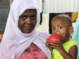 Una madre carga a su hijo después de ser resctados del Mediterráneo. EFE / Z. Maulana