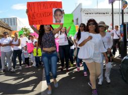 Los manifestantes visten de blanco y portando pancartas en las que exigían justicia. AFP / S. Gandara