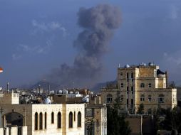 Una columna de humo se eleva entre los edificios de Yemen tras los ataques aéreos liderados por Arabia Saudita. EFE / Y. Arhab