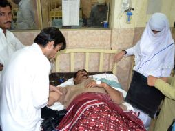 Paramédicos atienden al chofer de uno de los camiones secuestrados, quien resultó herido en el enfrentamiento durante el rescate. AFP / B. Kahn