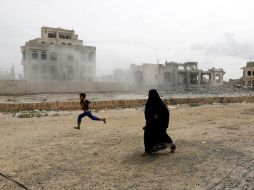 Una mujer y un niño yemení corren para ponerse salvo mientras la coalición vuelve a atacar la casa de un líder de los hutíes en Saná. EFE / ARCHIVO