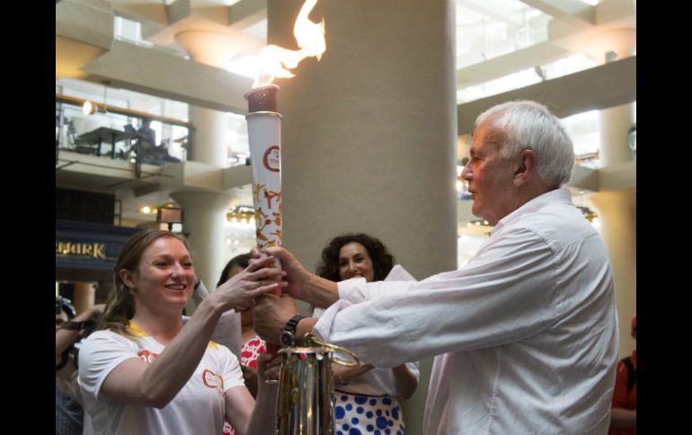 La atleta Rosie MacLennan recibe la antorcha de los Juegos Panamericanos Toronto 2015 del presidente David Petterson. AP / F. Gunn