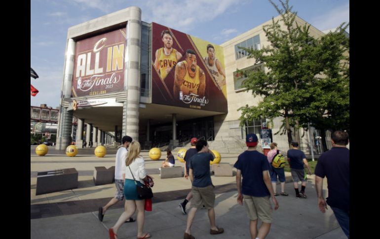 Personas caminan a las afueras del Quicken Loans Arena, que esta noche será escenario del tercer juego entre Cavaliers y Warrios AP / T. Dejak