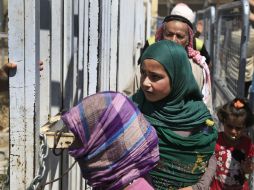 Alrededor de 200 hombres, mujeres y niños, con sus hatos a cuestas, cruzan el puesto fronterizo de Akçakale. AP / L. Pitarakis