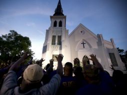 Además, miembros de la fraternidad Omega presidieron una oración afuera del templo de la Iglesia Episcopal Metodista Africana Emanuel. AFP / J. Raedle