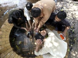 Varios hombres se refrescan un caluroso día en Karachi, mientras ha comenzado a llover en algunas de las zonas afectadas. EFE / R. Khan