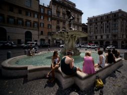 Turistas enfrían sus pies en la fuente de Roma ante las altas temperaturas que se registran. AFP / F. Monteforte