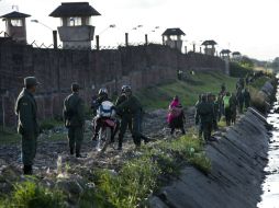Soldados y policías montan guardía de seguridad fuera del Centro de Reeducación de Santa Cruz-Palmasola que visitó el Papa. AP / R. Abd