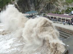 Varias personas observan las enormes olas mientras el tifón Chan-hom se acerca a Wenling, en la provincia Zhejiang. AFP / STR