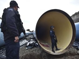 Policías federales revisan ductos de una obra en construcción en busca de algún indicio de Joaquín Guzmán. AFP / Y. CORTÉZ