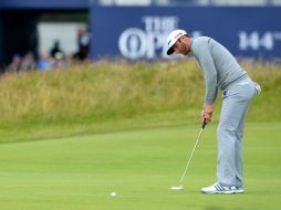 El estadounidense Dustin Johnson utiliza su putt en el primer día de actividades en el Abierto Británico. AFP / G. Kirk