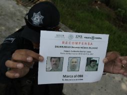 Un policía muestra un aviso de recompensa por Joaquín 'El Chapo' Guzmán. EFE / A. Cruz