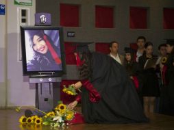 Los graduados de la generación 2012-B – 2015-A dejan flores ante el retrato de Lucía Yesenia González como homenaje. ESPECIAL / UdeG