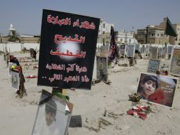 Banderas religiosas , fotografías y homenajes a 21 víctimas de un atentado suicida contra una mezquita chií , en un cementerio de al- Q AP / H. Jamali