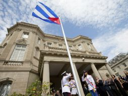 El canciller cubano, Bruno Rodríguez (c-d) tras izar la bandera nacional en la que será la embajada del país en Washington. EFE / A. Harnik