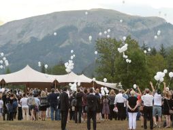 Los familiares sueltan globos blancos durante la ceremonia para dar el último adiós a quienes perdieron la vida en el accidente. AFP / B. Horvath