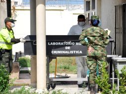 Forenses y un integrante de la policía bajan el cuerpo de uno de los militares fallecidos en el hospital Rosario Pumarejo. EFE / A. Guerra