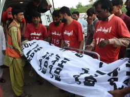 Voluntarios paquistaníes desplazan el cuerpo de Shafqat Hussain a un depósito de cadáveres luego de su ejecución. AFP / A. Hassan