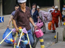 Las personas que viven cerca de Tianjin abandonan sus casas con sus pertenencias. AFP /