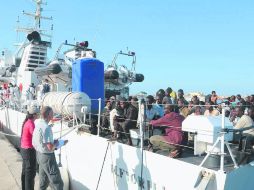 ITALIA. Algunos de los 250 inmigrantes rescatados en el Mar Mediterráneo desembarcan de una nave de la Guardia Costera italiana. AFP /