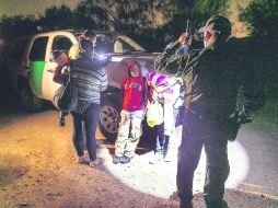 Una familia de inmigrantes, en la línea divisoria entre México y Estados Unidos, cerca de Río Bravo en McAllen. AP /