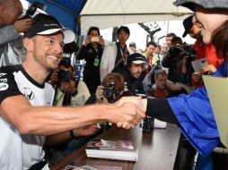 El piloto británico Jenson Button, de McLaren, reparte autógrafos entre sus fans en el circuito de Suzuka. AFP / T. Yamanaka