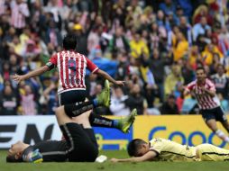 Omar Bravo (de espaldas) festeja el segundo gol del Clásico ante la impotencia de dos jugadores americanistas en el Estadio Azteca. EFE / J. Méndez