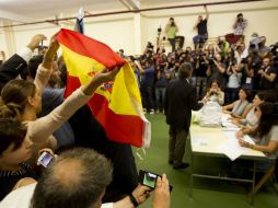 Varios de sus detractores le mostraron la bandera de España mientras emitía su voto. AP / E. Morenatti
