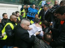 Agentes de seguridad tuvieron que escoltar al dirigente, descamisado. AP / J. Brinon