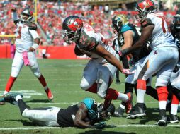 Doug Martin (c) corrió para 123 yardas y logró tres anotaciones. AFP / C. McBride